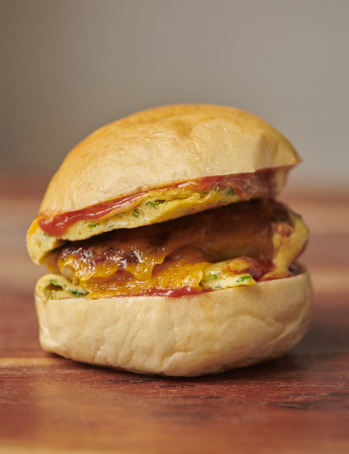 Breakfast sandwich with omelette, sausage and cheddar